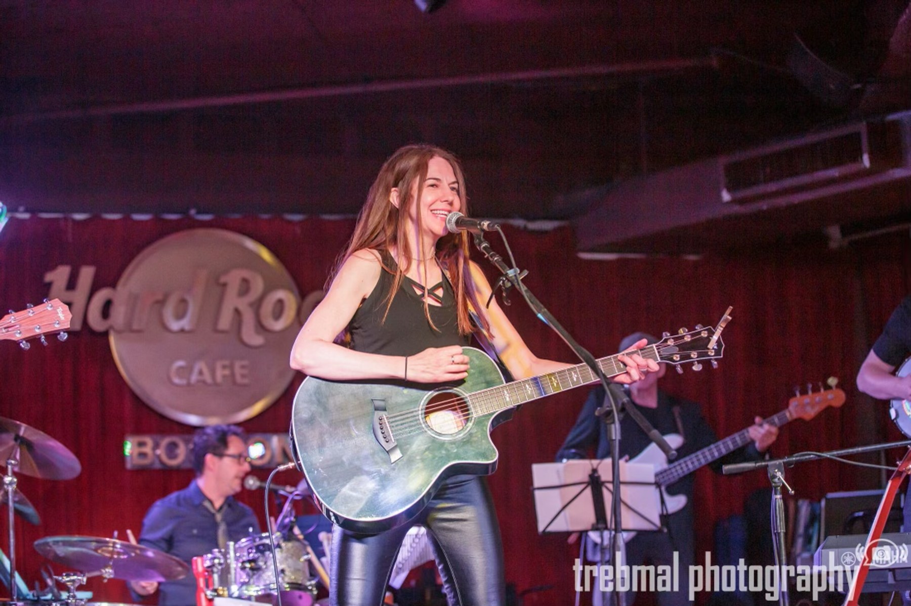 Sara Wheeler singing and playing guitar with her band at Hard Rock Cafe